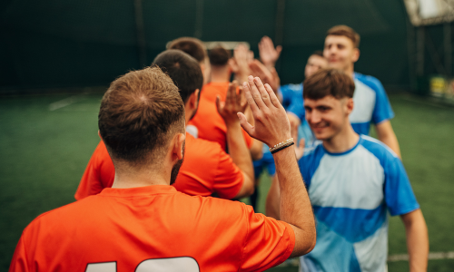 Two teams lined up clapping hands after a game.